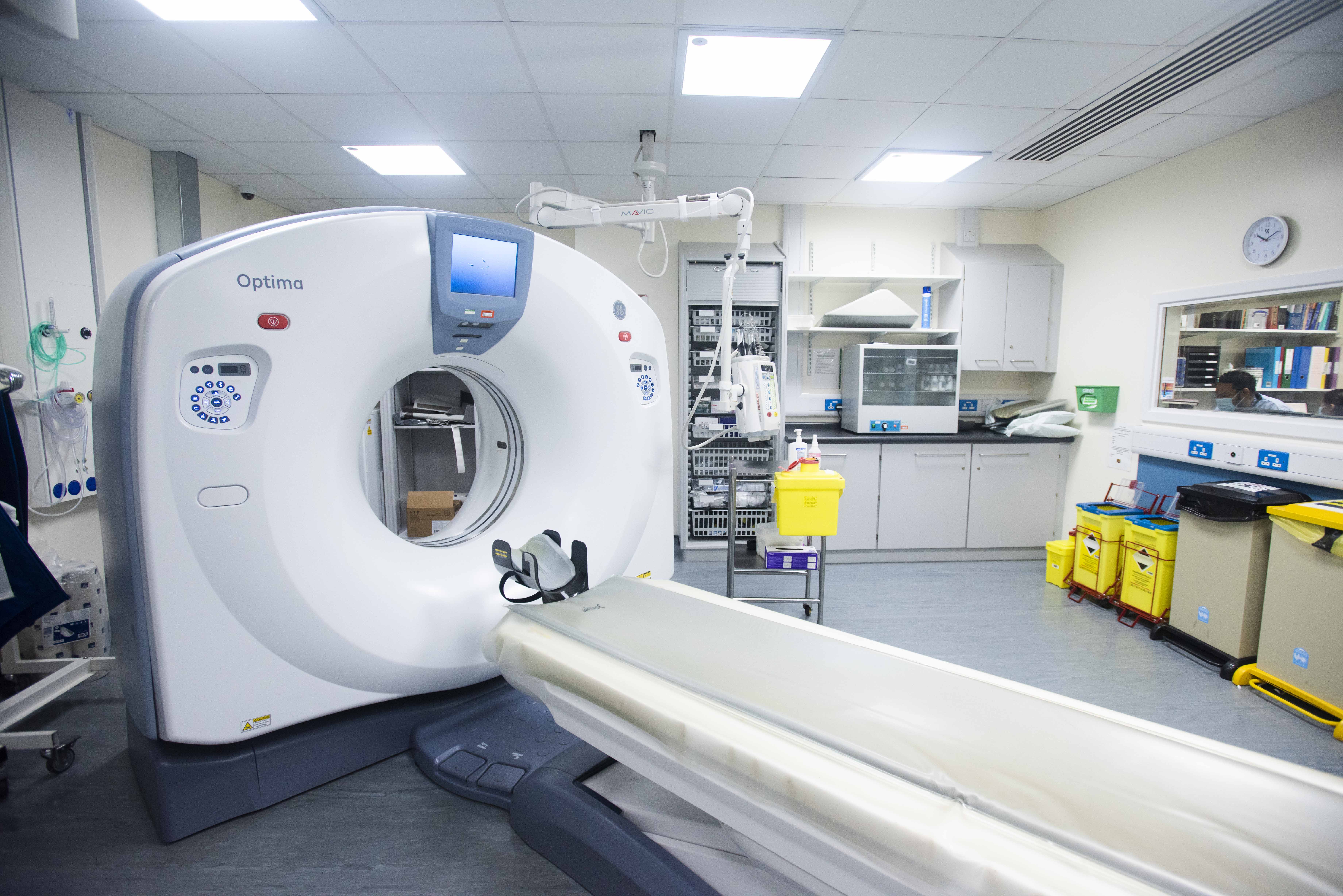 The table that the patient is asked to lay on, and the CT scanner that is shaped like a large doughnut.