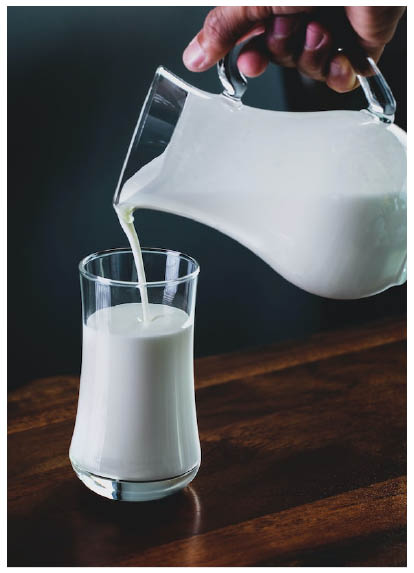 Photo of a glass of milk being poured from a jug
