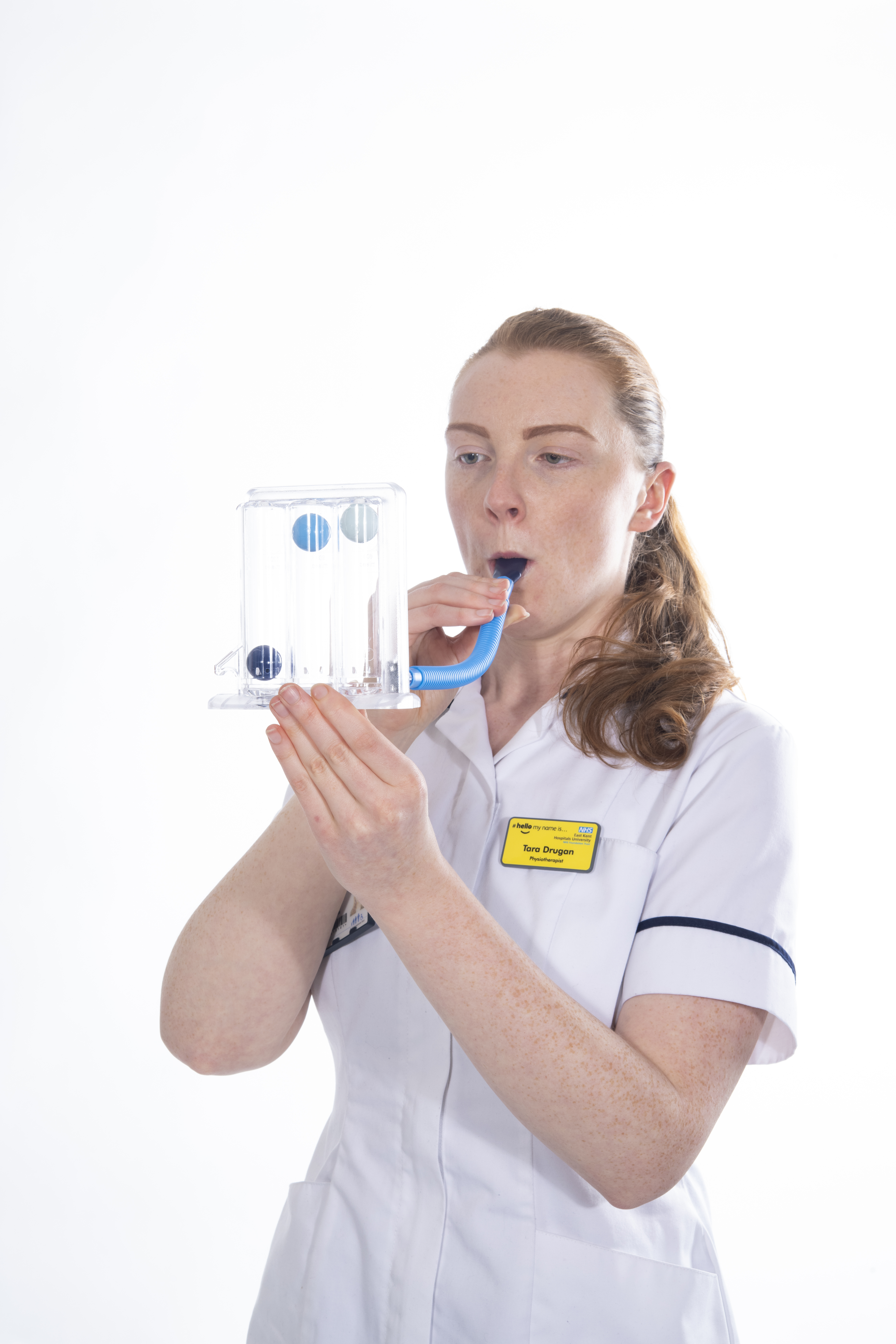 Blow into the incentive spirometer and make two balls rise