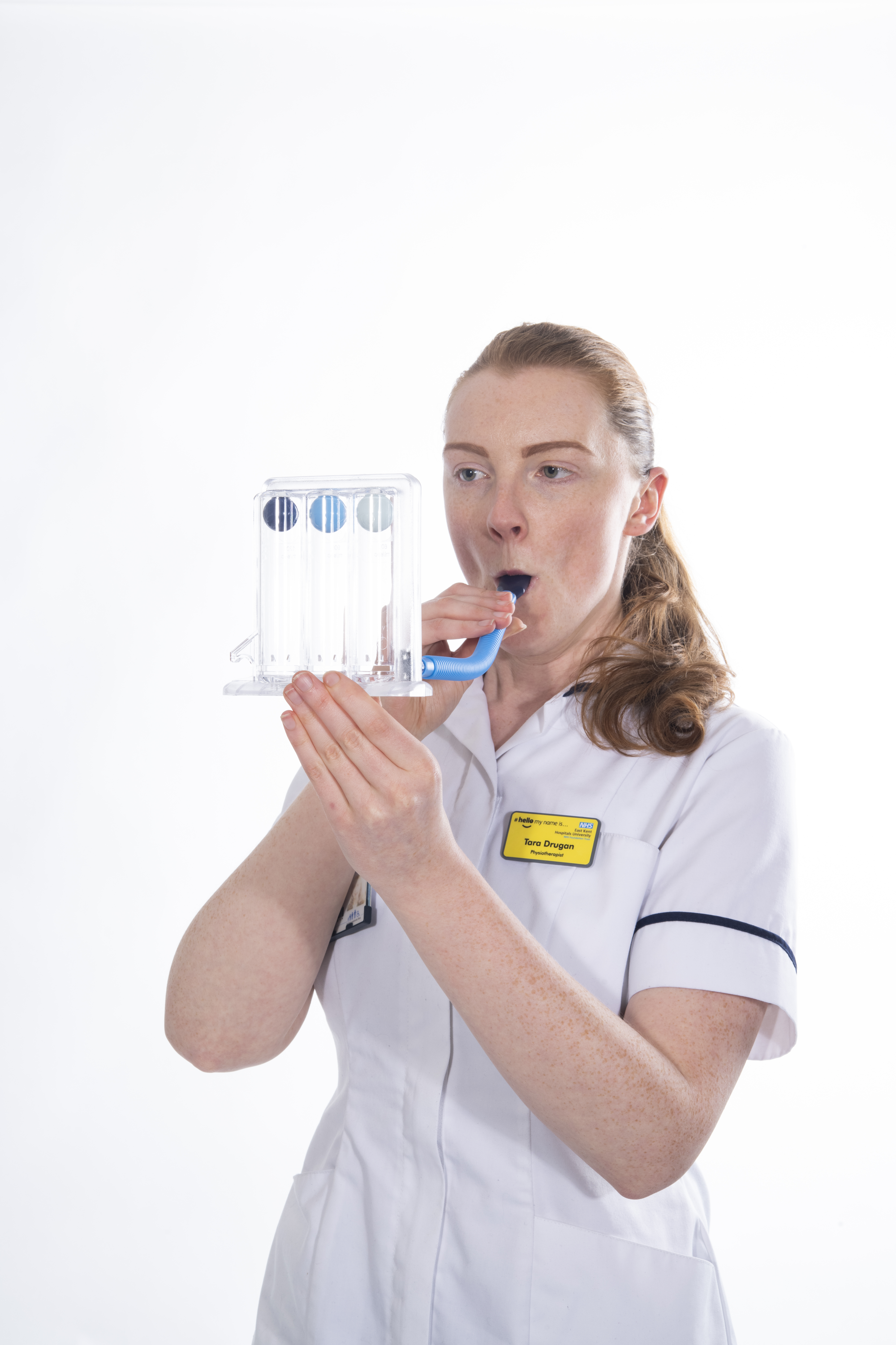 Blow into the incentive spirometer and make three balls rise