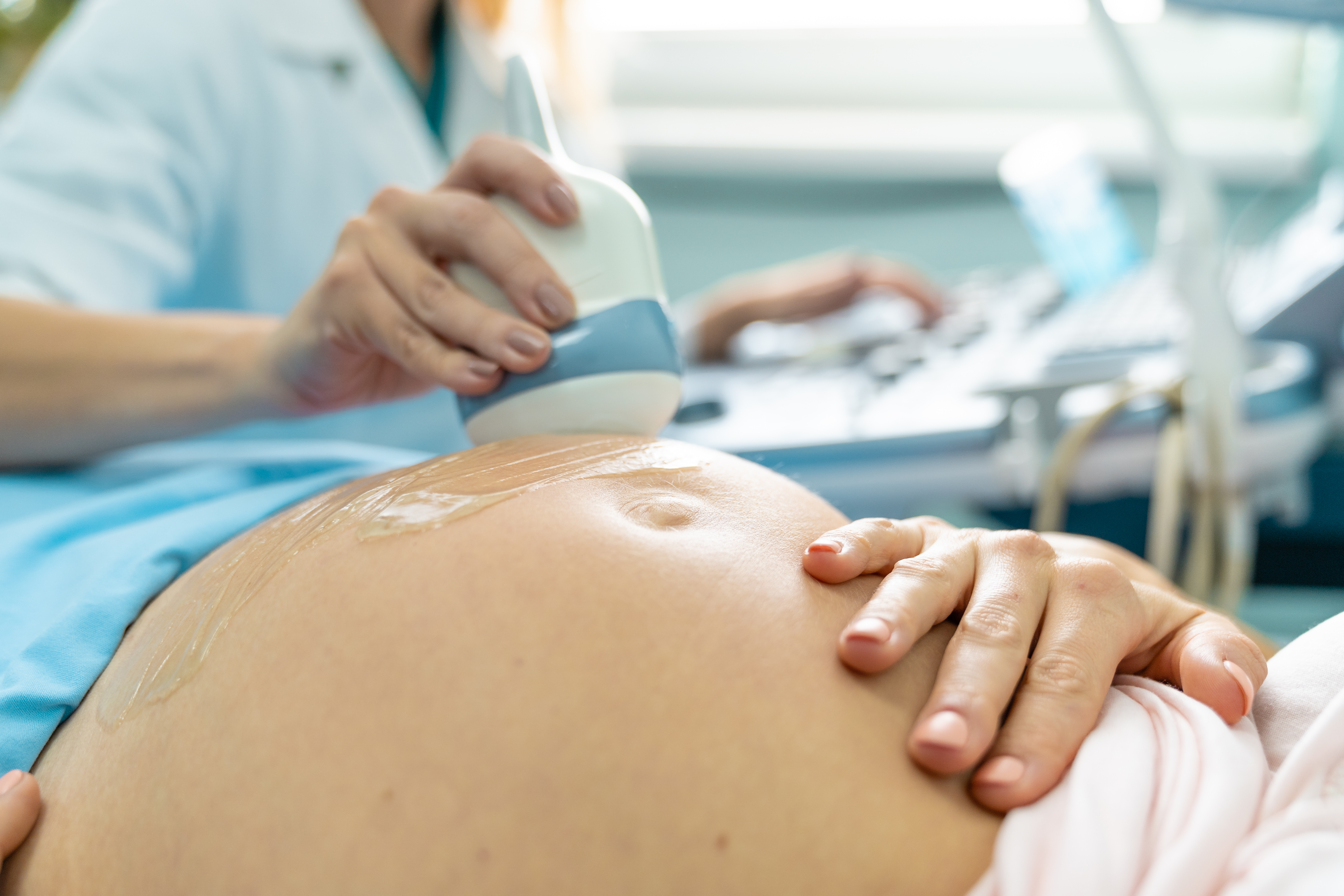 Photo showing sonographer placing gel on the lower tummy