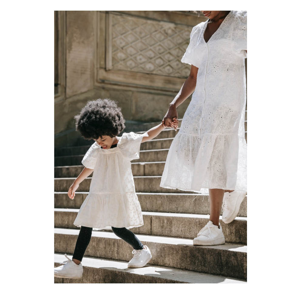 Parent and child holding hands and walking down steps